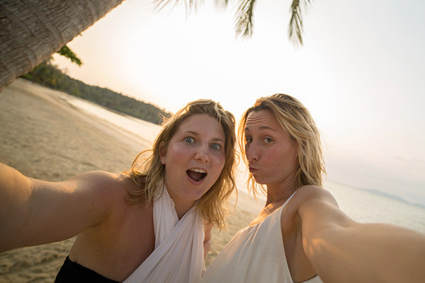 To jenter tar selfiebilde på en strand. Foto